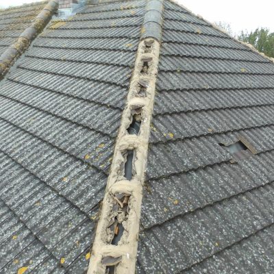 damaged roof with missing ridge tiles following a storm