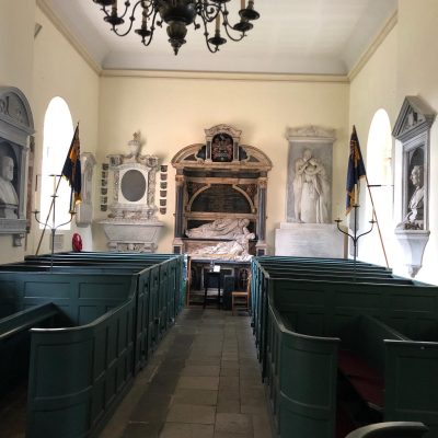 inside of an old church showing wall decorations and the old painted pews